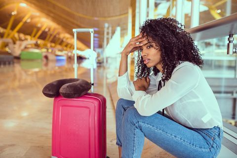 امرأة سوداء منزعجة ومحبطة في المطار مع إلغاء الرحلة